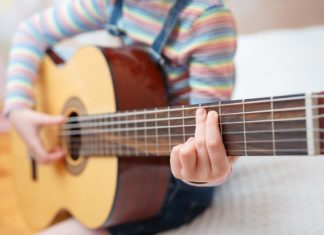 Niña tocando la guitarra en actividades extraescolares