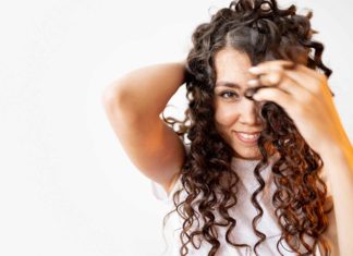 Mujer luce cabello rizado con el método curly girl